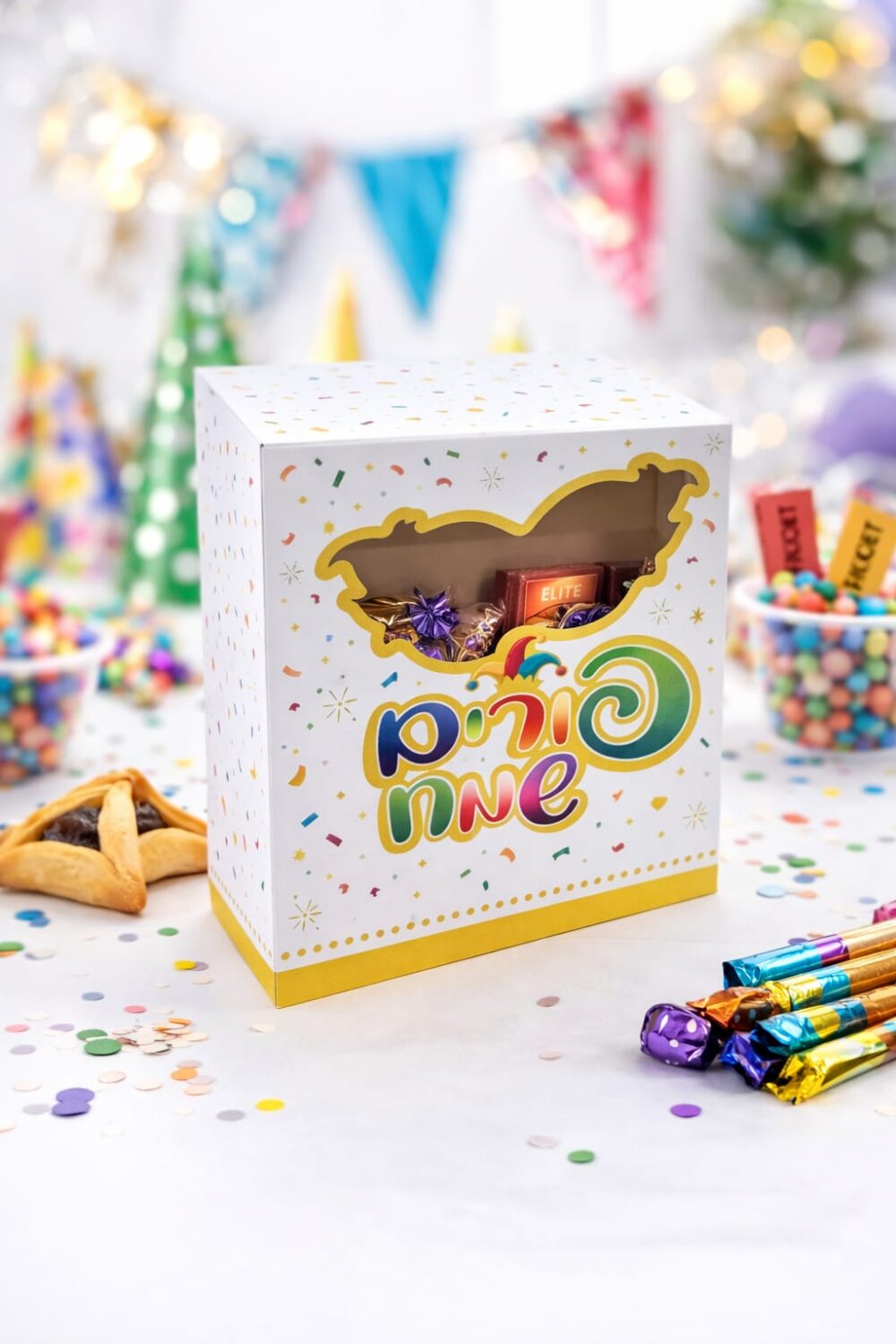 קופסת קרטון לפורים עם חלון שקוף בעיצוב מסכה צבעוני – מושלמת למשלוחי מנות ומתנות חג מרשימות.